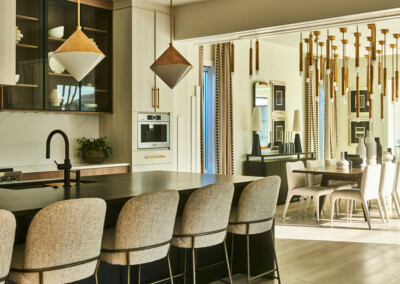 Modern kitchen with bar stools and pendant lighting.