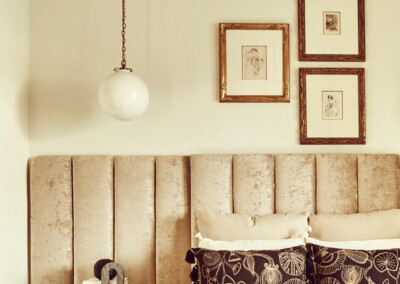 Cozy bedroom with tufted headboard and pendant light.