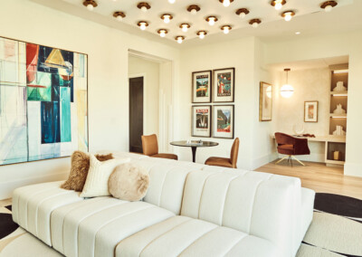 Elegant living room with white sectional sofa and modern art.