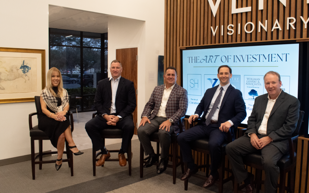 Five professionals pose for a photo in a modern office setting with a large logo behind them.
