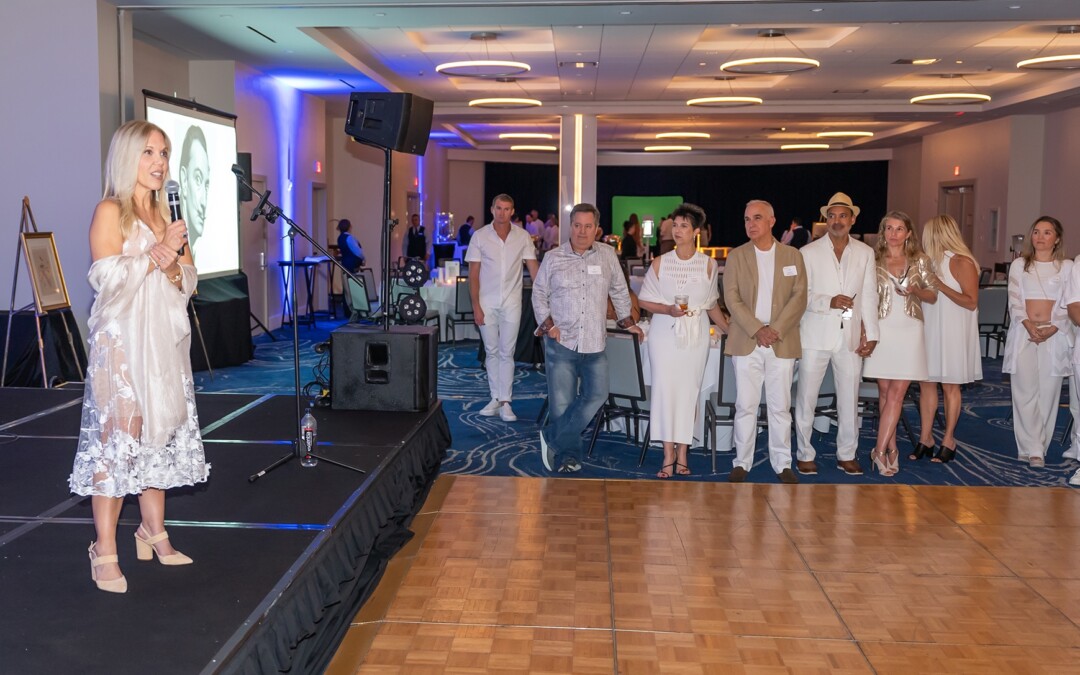 People gathered at an indoor event with a stage and microphone.